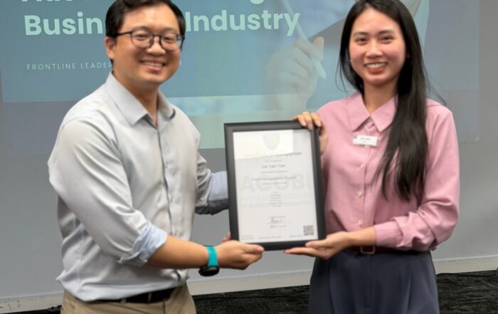 A participant receiving a certificate of completion for the Frontline Leadership Program in Vietnam